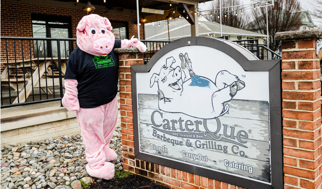 pig maskot next to carterque sign